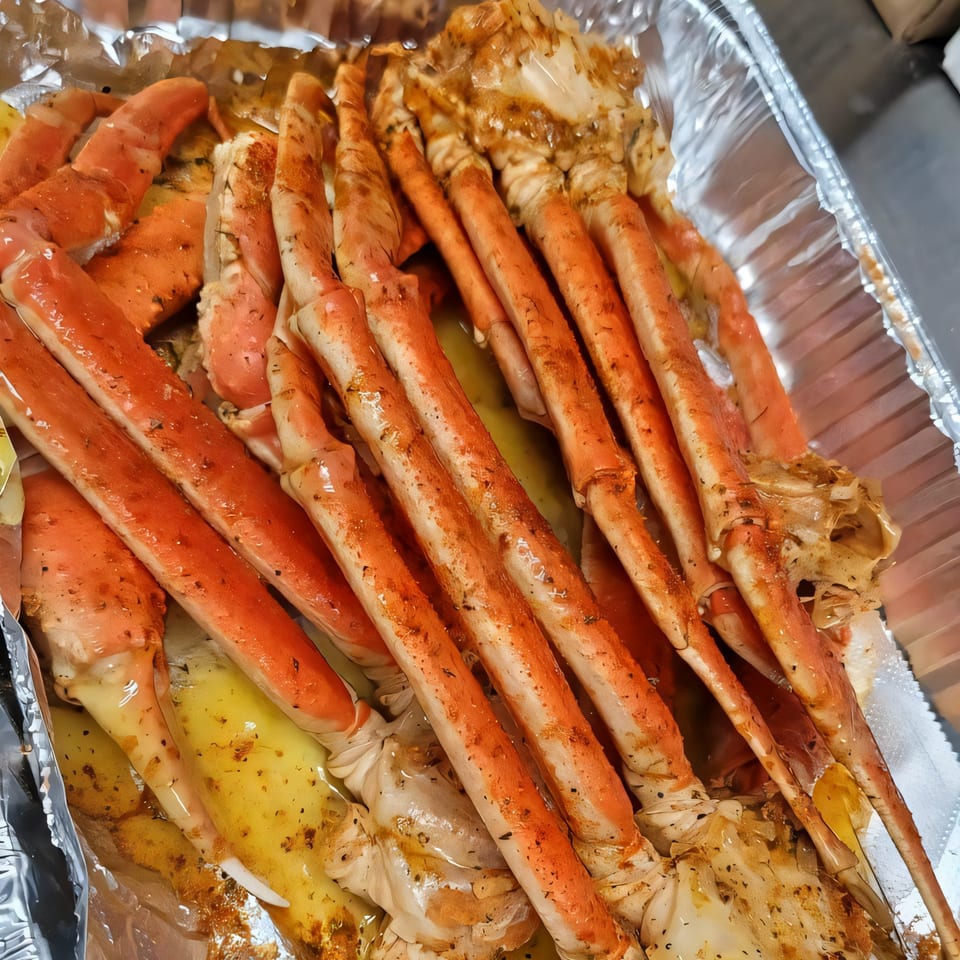 Walton's Fresh Fish Seafood crab legs, seasoned and cooked in a foil pan.