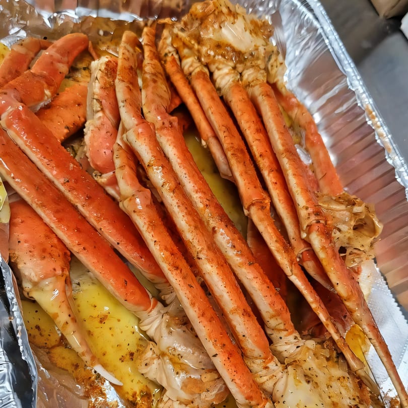 Walton's Fresh Fish Seafood crab legs, seasoned and cooked in a foil pan.